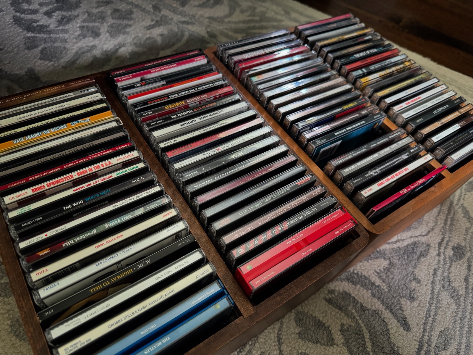 A wooden case full of CDs, including Crosby Stills & Nash, Led Zeppelin, The Beatles and U2