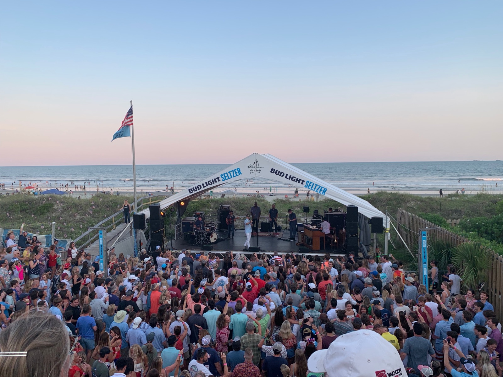 JJ Grey and Mofro playing a beachside stage to a packed crowd at sunset