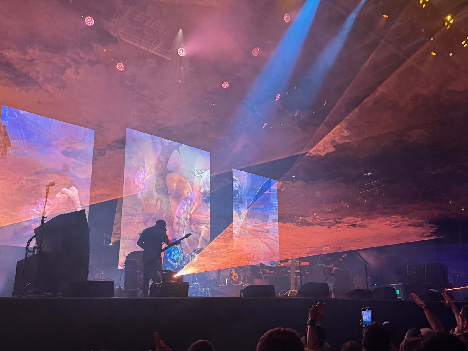 Slightly Stoopid on stage under orange and blue lights and projected visuals